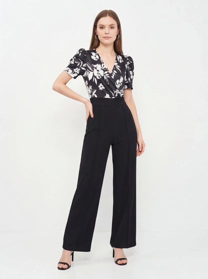 Jamota black floral print jumpsuit with wrap V-neck, short puff sleeves and wide-leg pants.