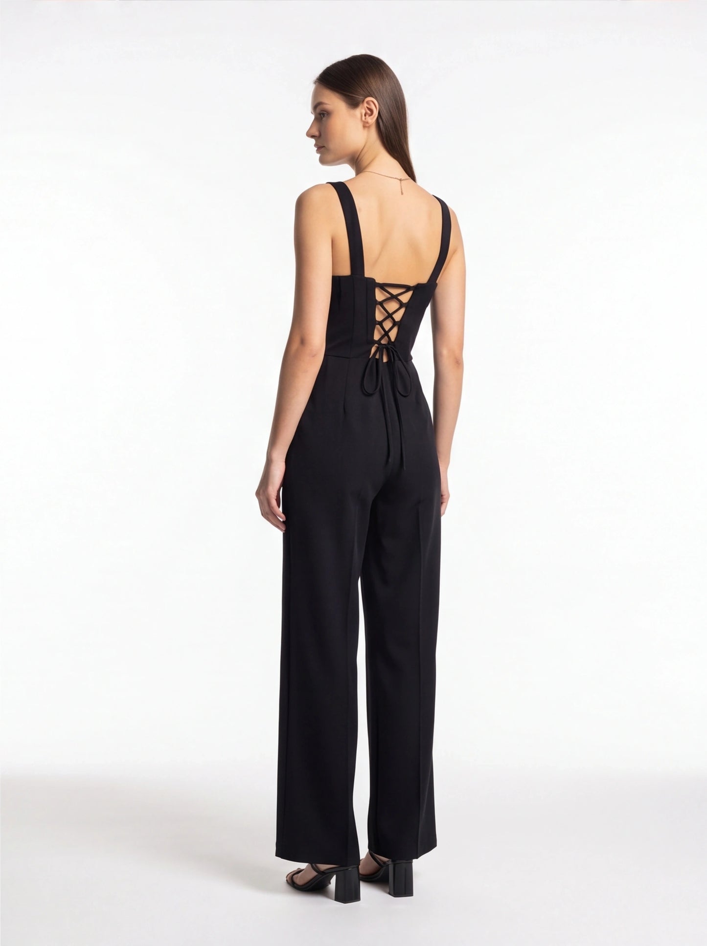 Jamota black women's jumpsuits with tailored-fit silhouette, wide straps, and criss-cross lace-back with bow.