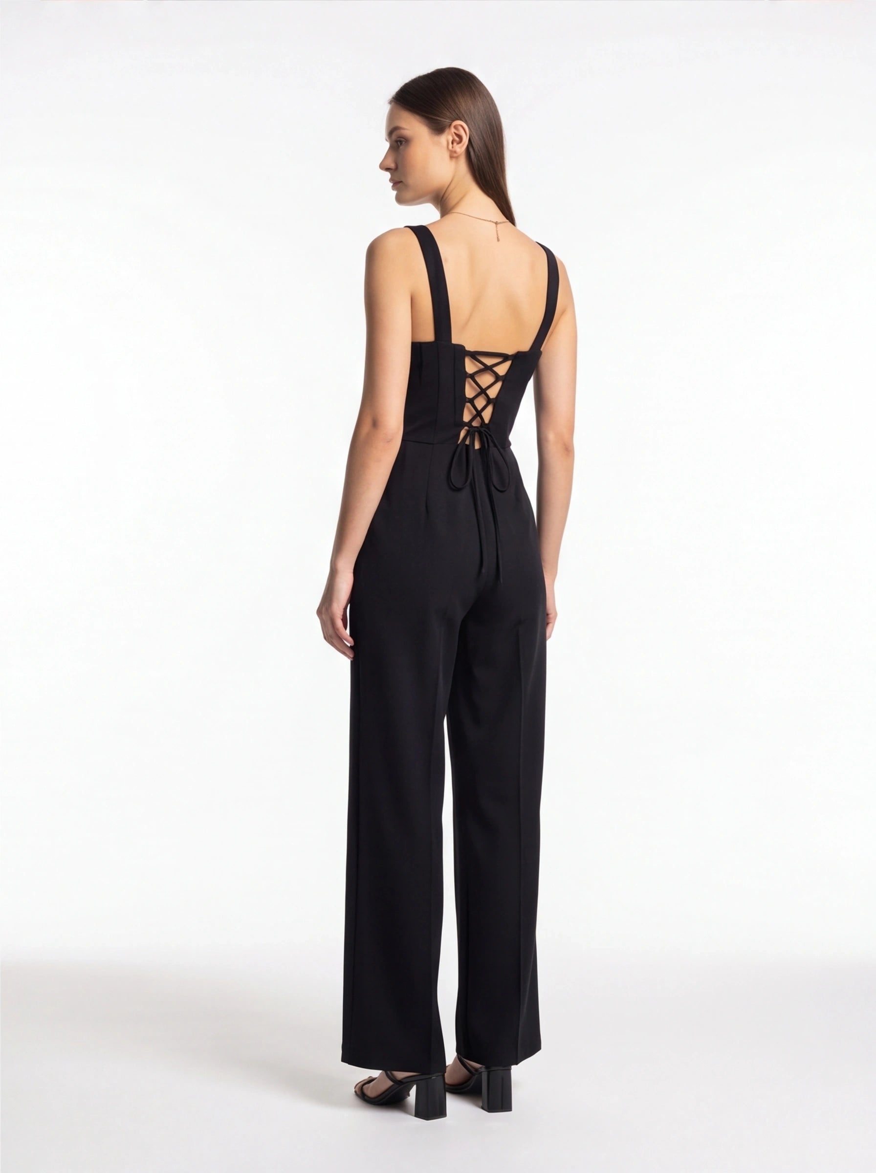 Jamota black women's jumpsuits with tailored-fit silhouette, wide straps, and criss-cross lace-back with bow.