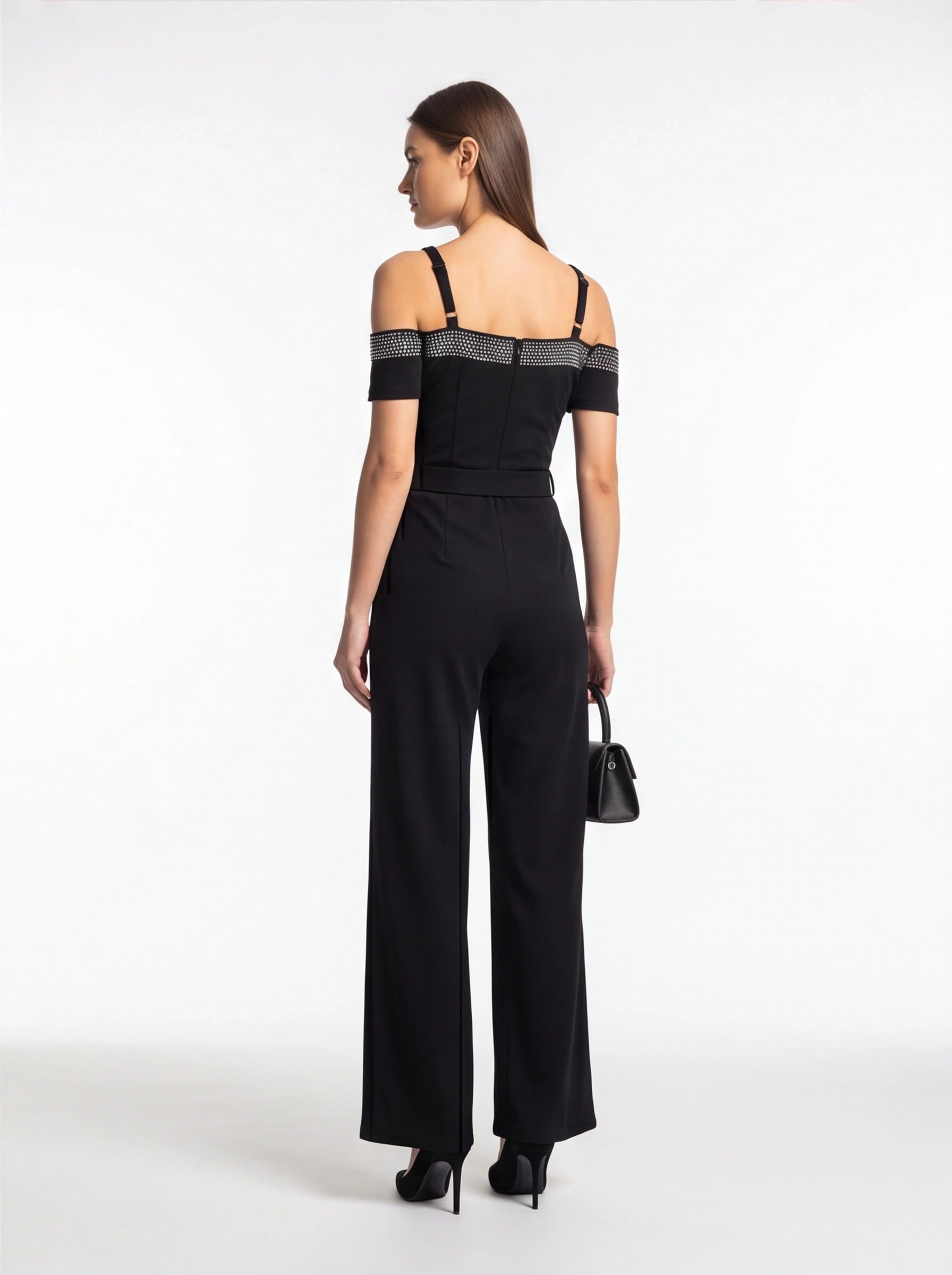 Jamota black jumpsuit with off-shoulder short sleeves, studded band across the upper back, and adjustable straps