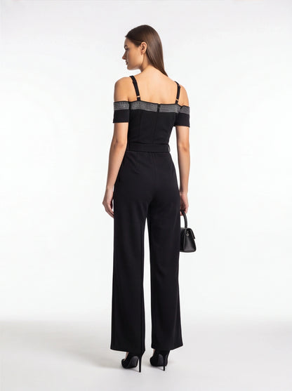 Jamota black jumpsuit with off-shoulder short sleeves, studded band across the upper back, and adjustable straps