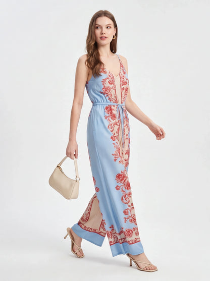 Jamota light blue jumpsuit with red floral print, adjustable straps and wide-leg silhouette.