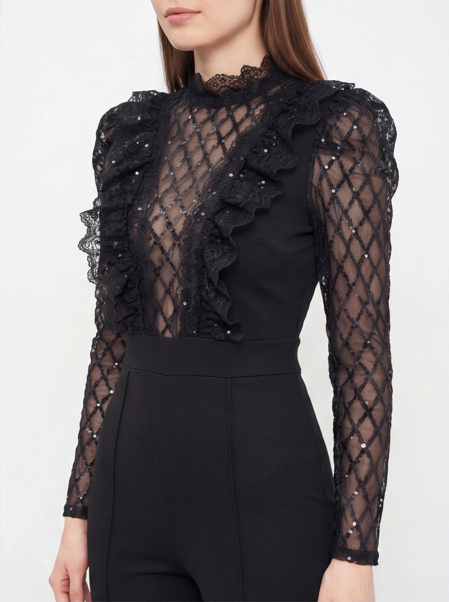 Jamota black jumpsuit with sheer lattice lace sleeves, high-neck lace and a ruffled front panel.