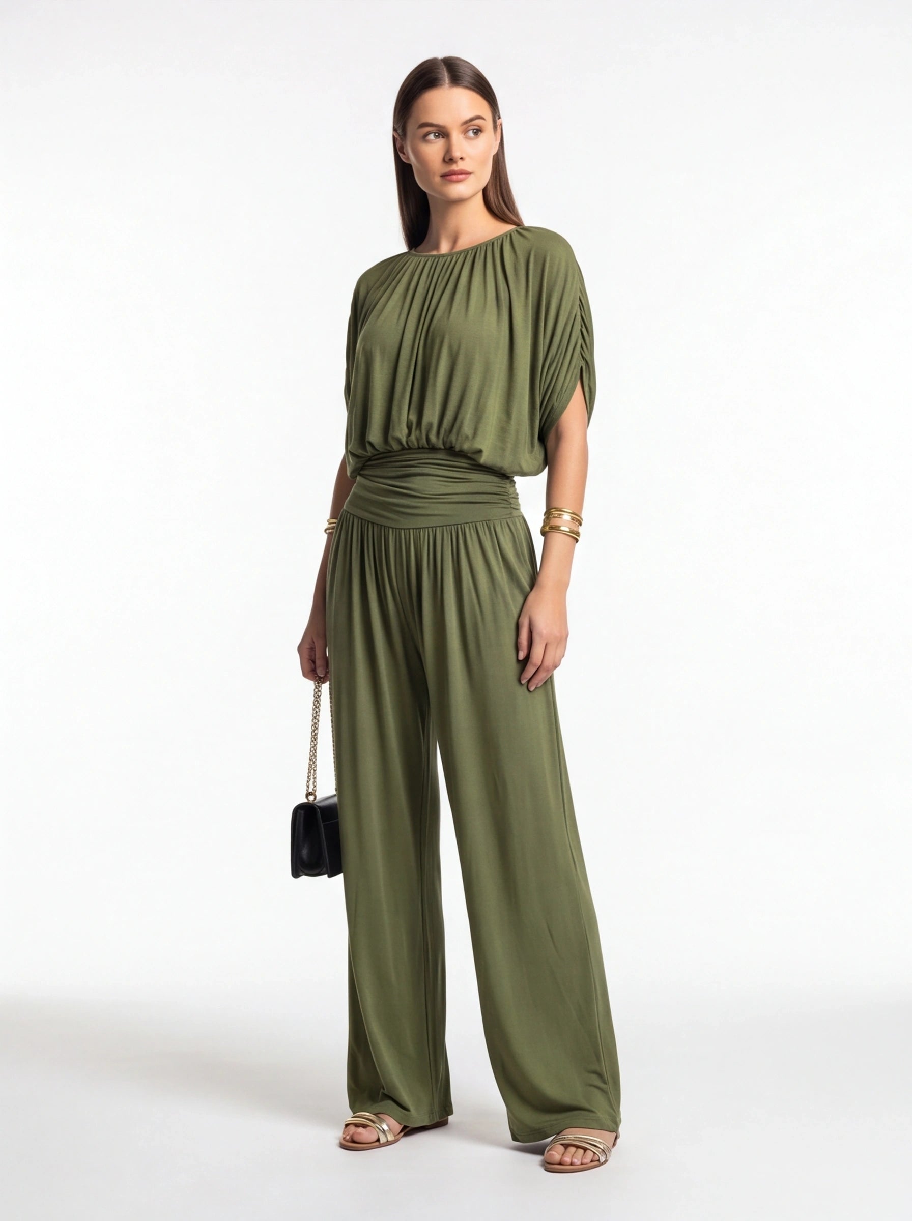 Jamota olive green jumpsuit with gathered neckline and ruched waist, wide-leg pants; model wearing gold bracelets.