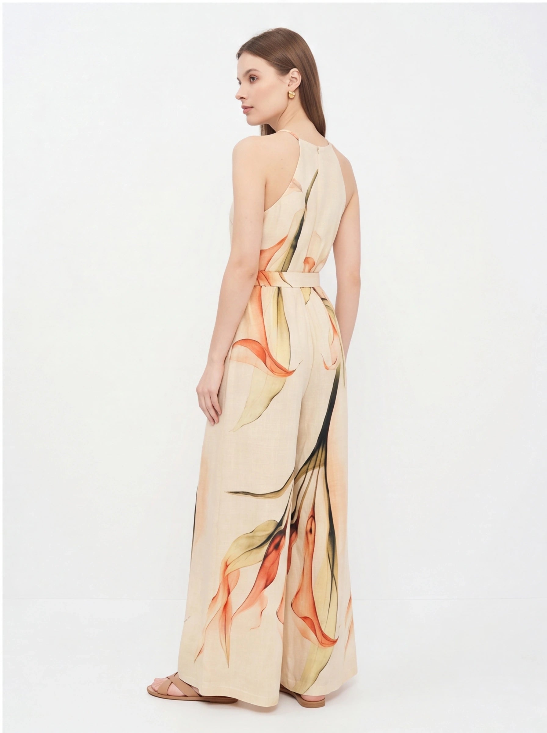 Jamota beige floral print jumpsuit with wide legs and a tied waist belt; back view shows a sleeveless halter neckline.