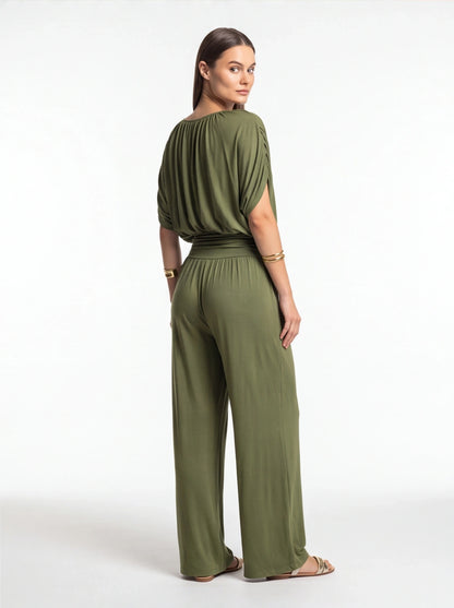 Jamota olive green jumpsuit with a draped top, cinched waist and wide-leg pants, back view.