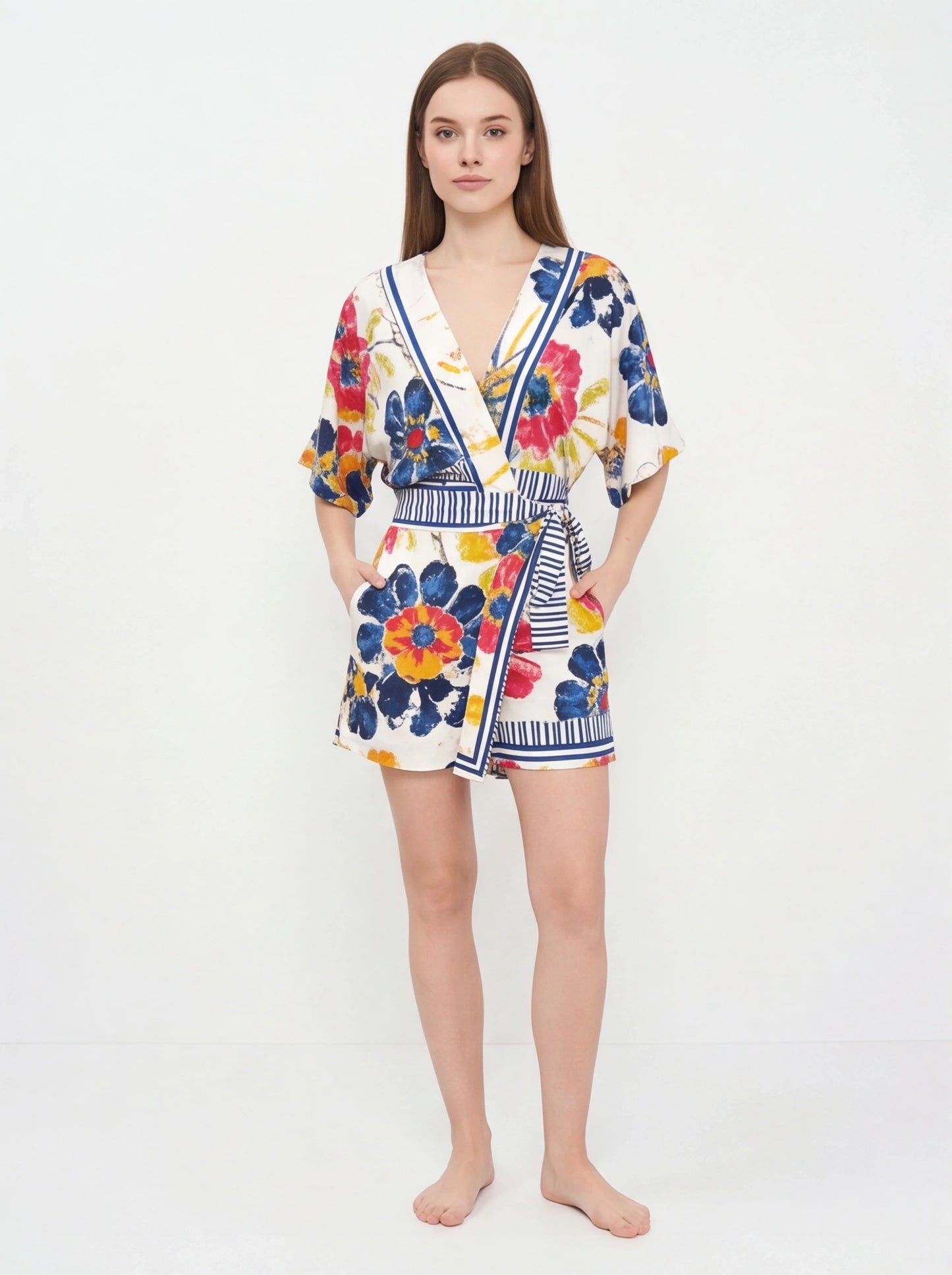Jamota floral print romper with V-neck, white base, colorful flowers, striped waist belt, pockets and adjustable straps.