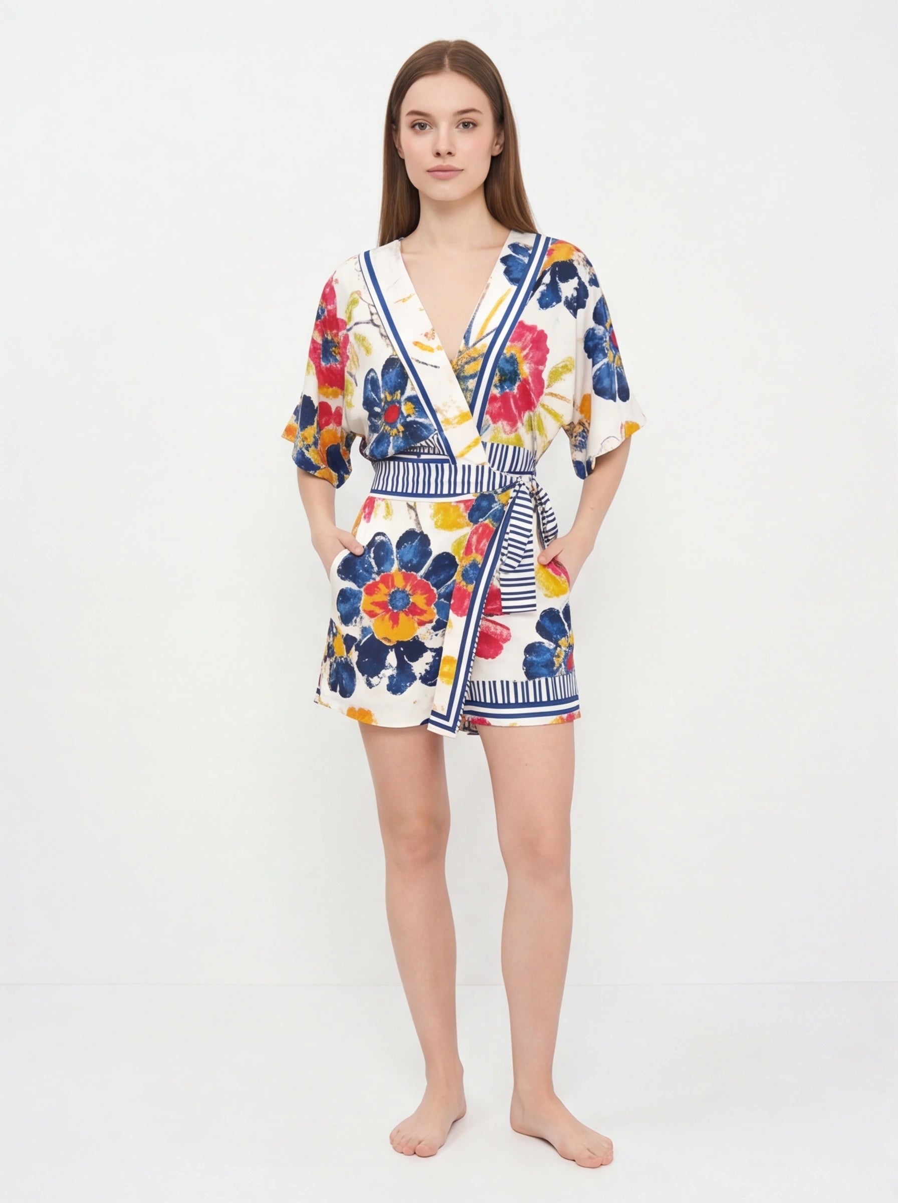 Jamota floral print romper with V-neck, white base, colorful flowers, striped waist belt, pockets and adjustable straps.