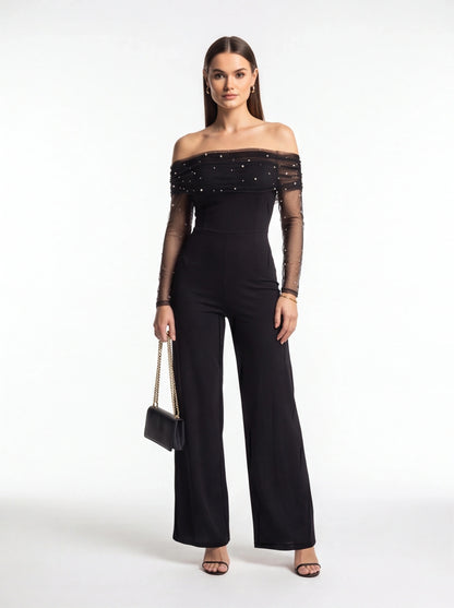 Jamota black off-shoulder jumpsuit with sheer dotted mesh sleeves and pearl accents, fitted bodice and wide-leg pants.