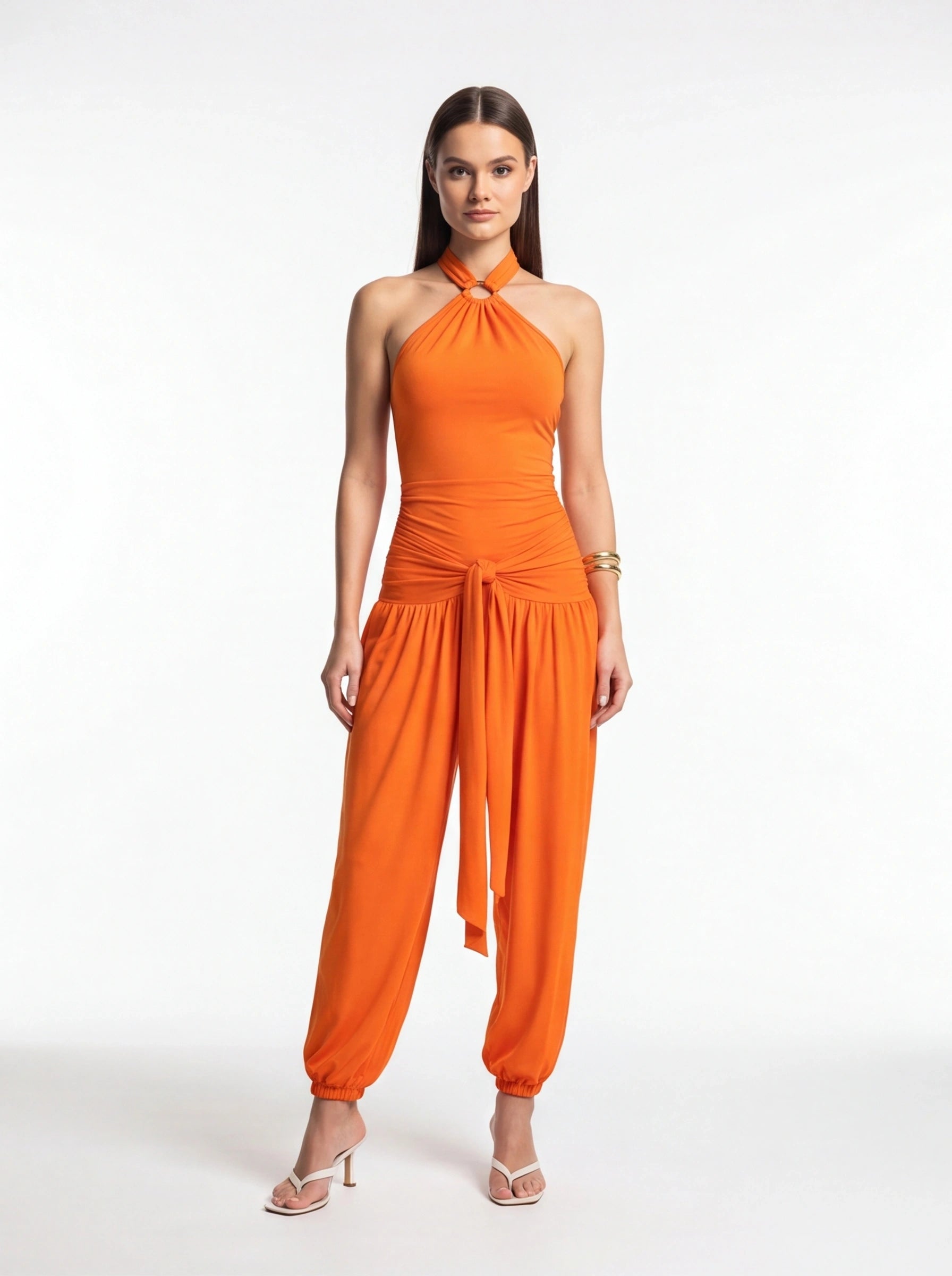 Jamota orange halter jumpsuit with ring neckline, ruched waist and front tie belt, elastic cuffs.