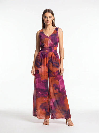 Jamota purple-pink-orange tie-dye jumpsuit with sleeveless V-neck, smocked waist and wide-leg pants.