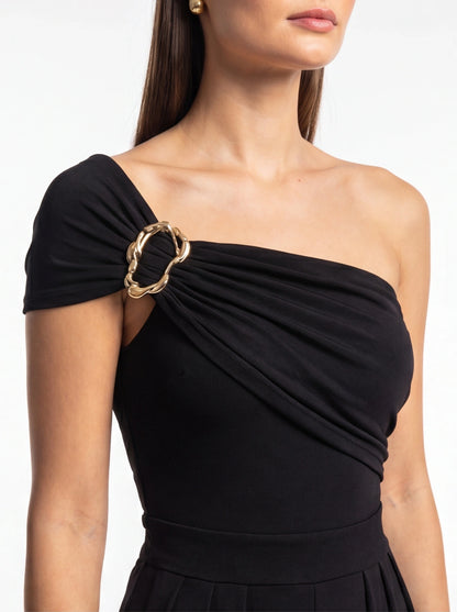 Jamota black jumpsuit with one-shoulder neckline and gold ring strap detail; high-waisted with pleated waistband.