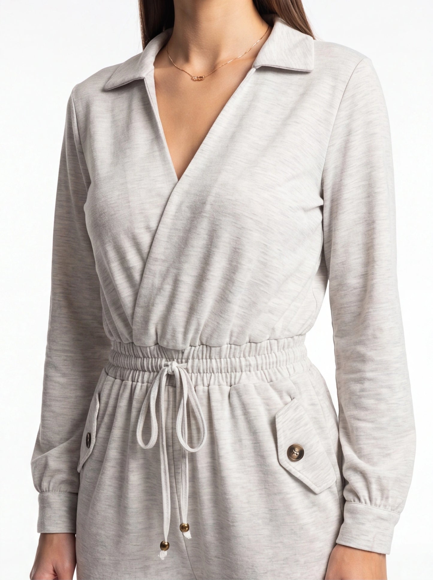 Jamota grey jumpsuit with wrap neckline, long sleeves, elastic waist, drawstring with beads, and buttoned pocket.
