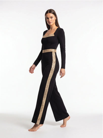 Jamota black jumpsuit with gold sequin stripes across the chest and down the sides, long sleeves, wide-leg pants.