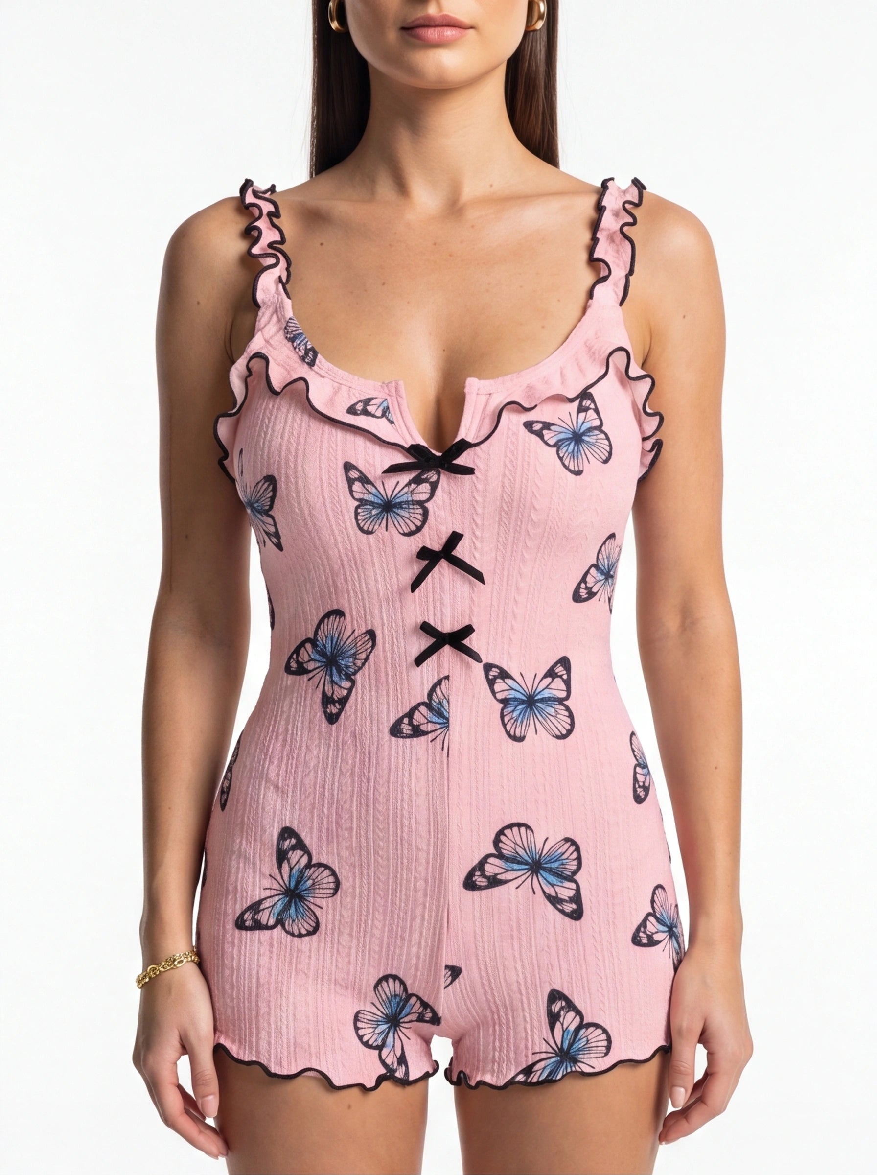 Jamota pink women's sleepwear onesie with butterfly print, ruffled straps, black trim, and front bow accents.