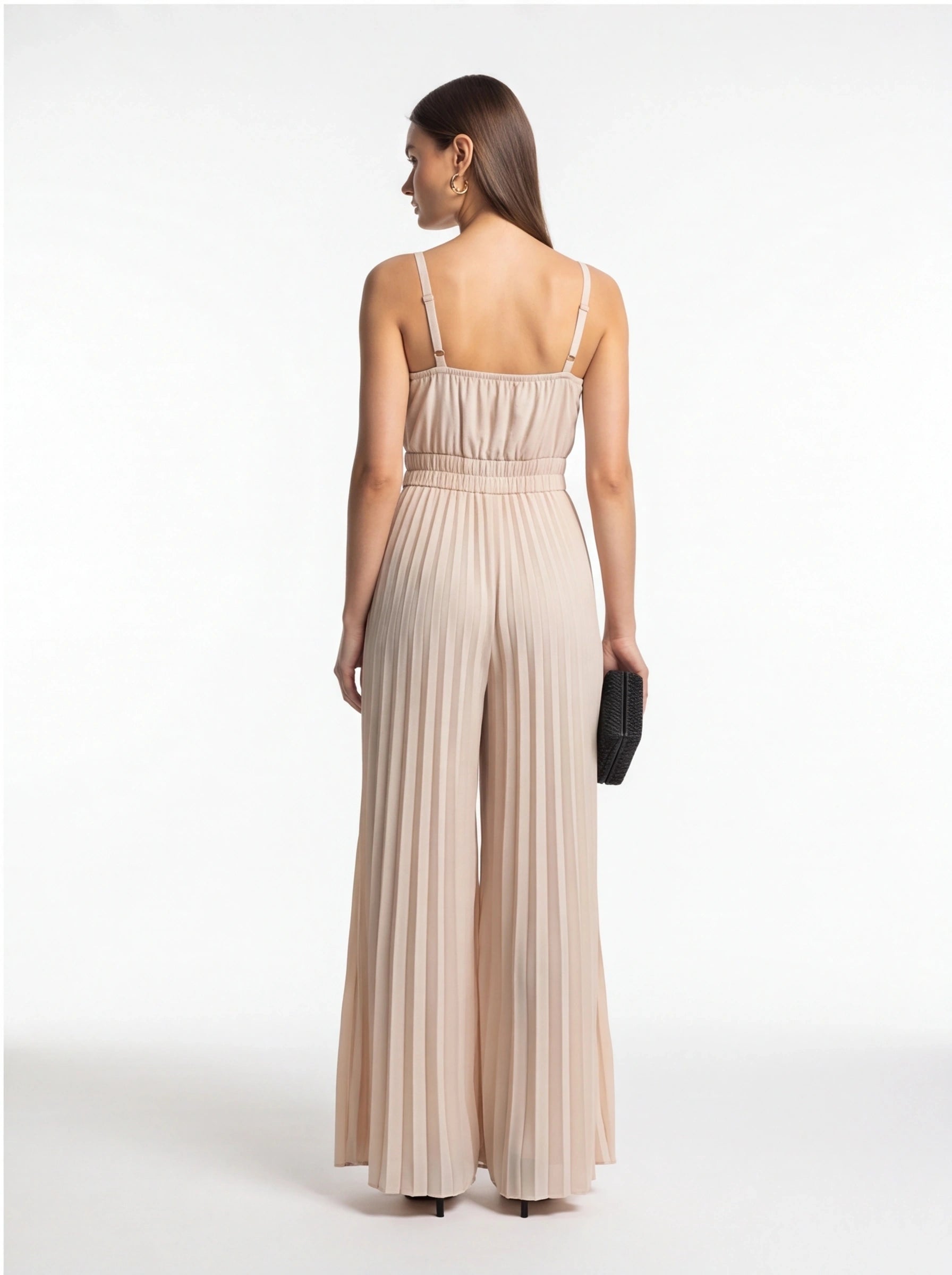 Jamota beige jumpsuit with adjustable straps, smocked waist and pleated wide-leg pants, back view.