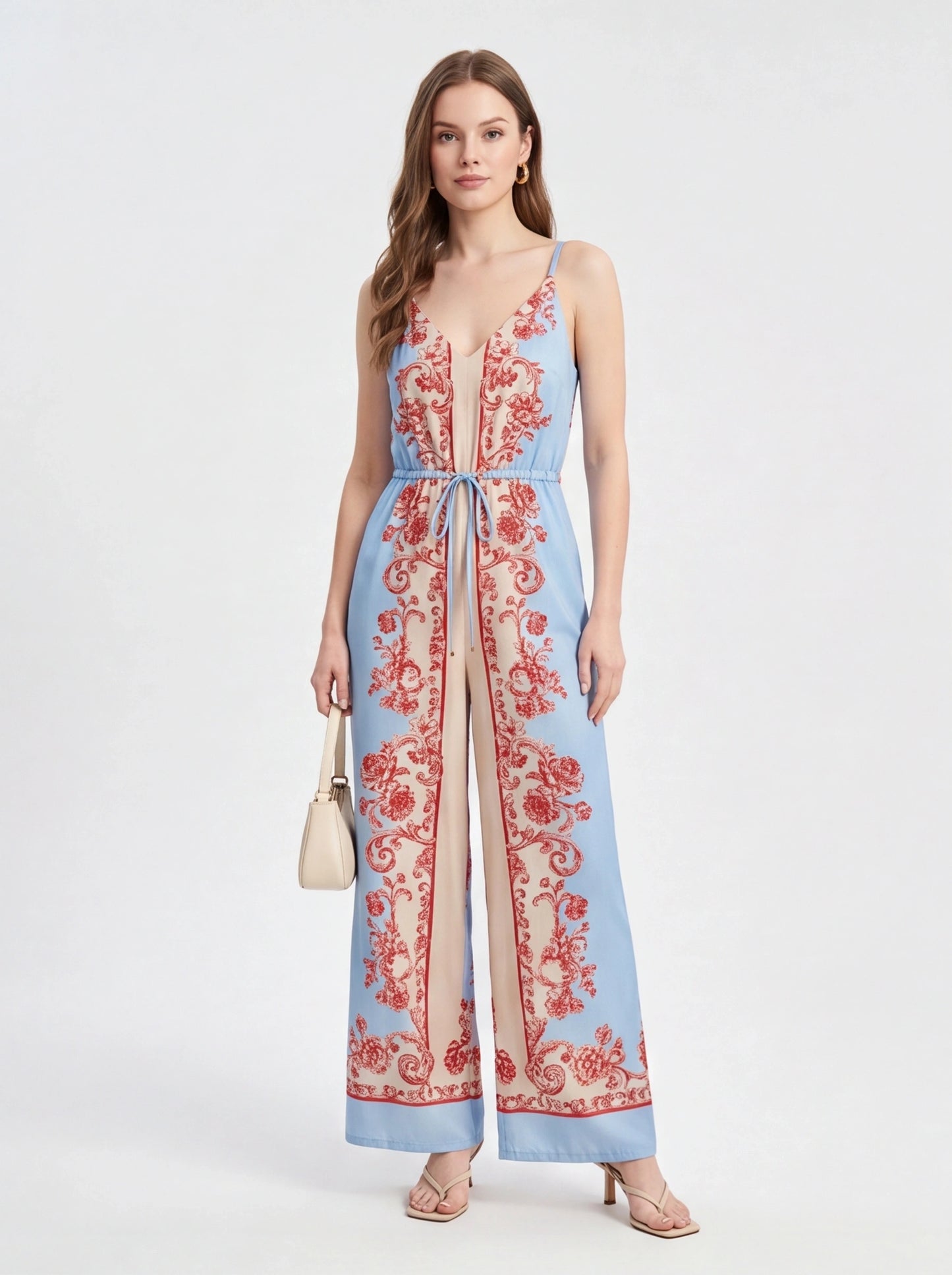 Jamota blue jumpsuit with red floral print, adjustable straps and wide-leg silhouette.