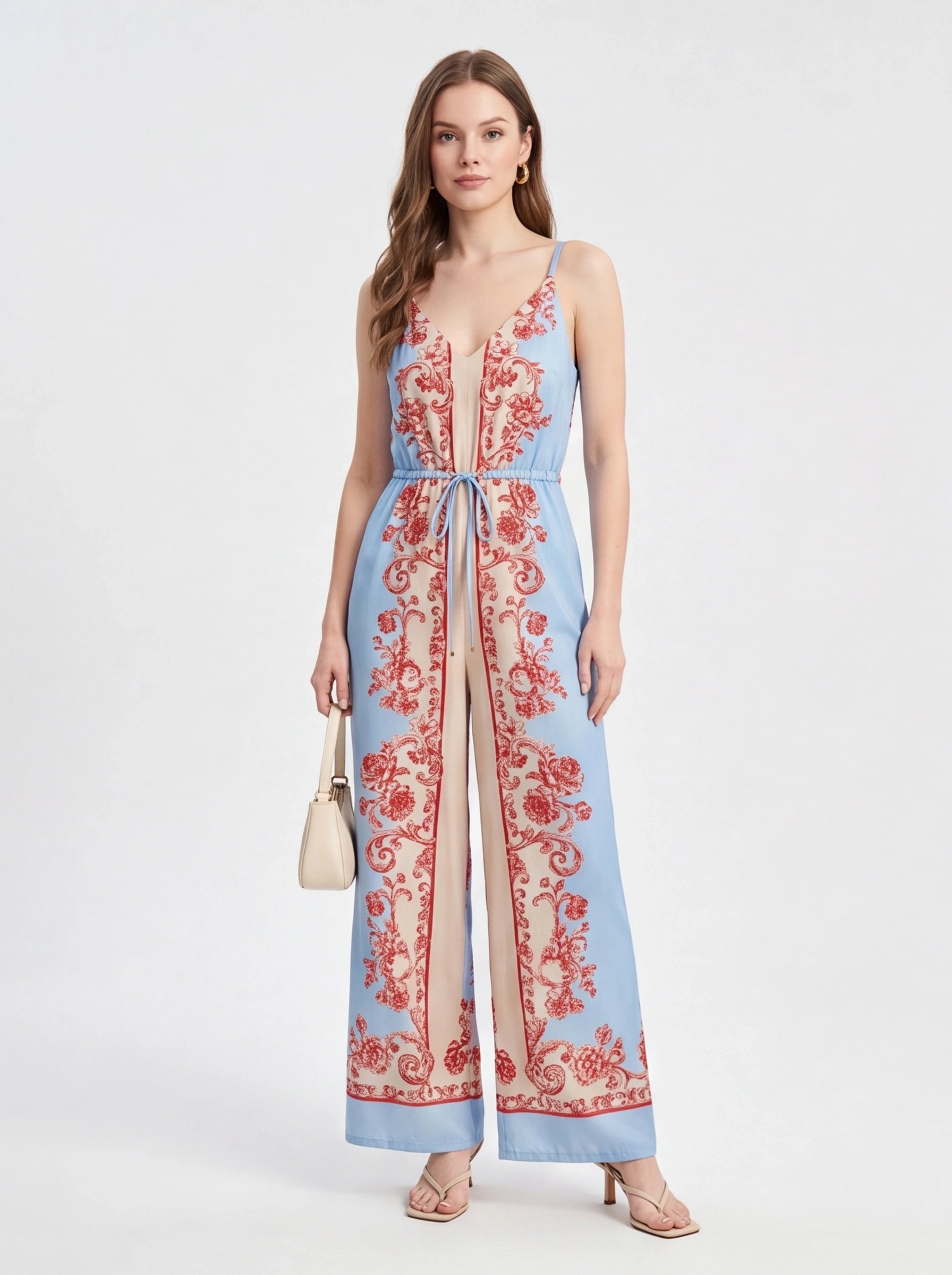 Jamota blue jumpsuit with red floral print, adjustable straps and wide-leg silhouette.