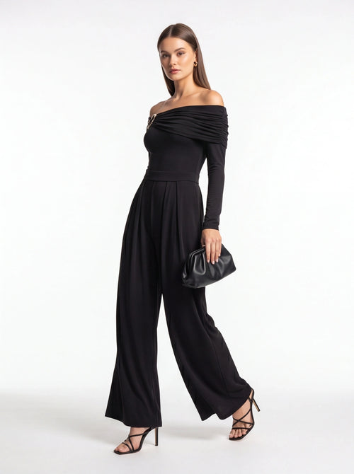 Jamota black jumpsuit with off-shoulder draped neckline, long sleeves, belt at waist and wide-leg pants