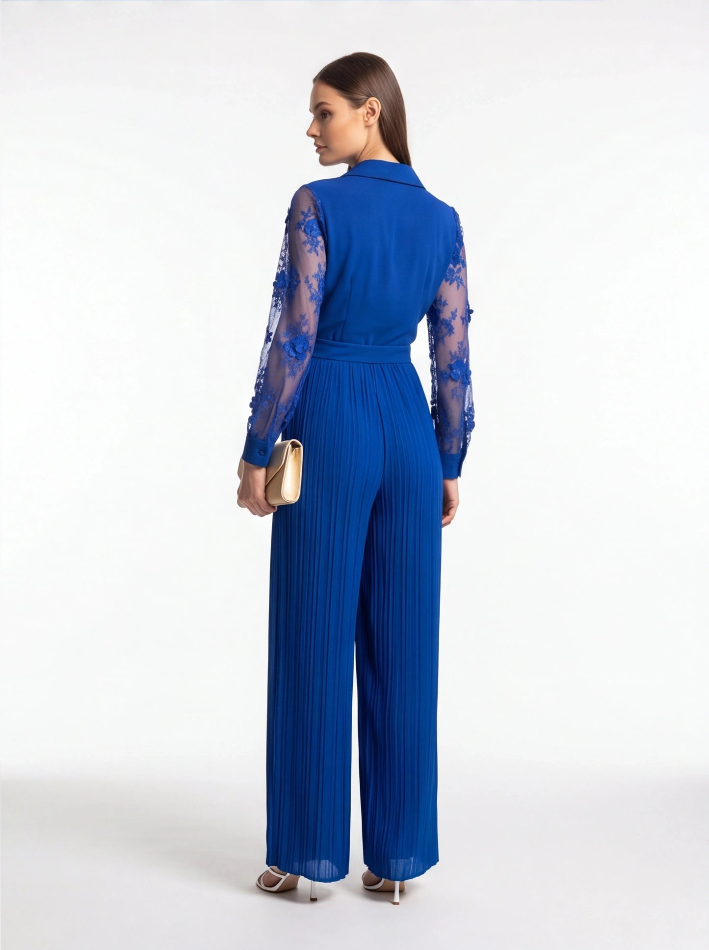 Jamota blue jumpsuit with sheer floral lace sleeves, belt at waist, and pleated wide legs.