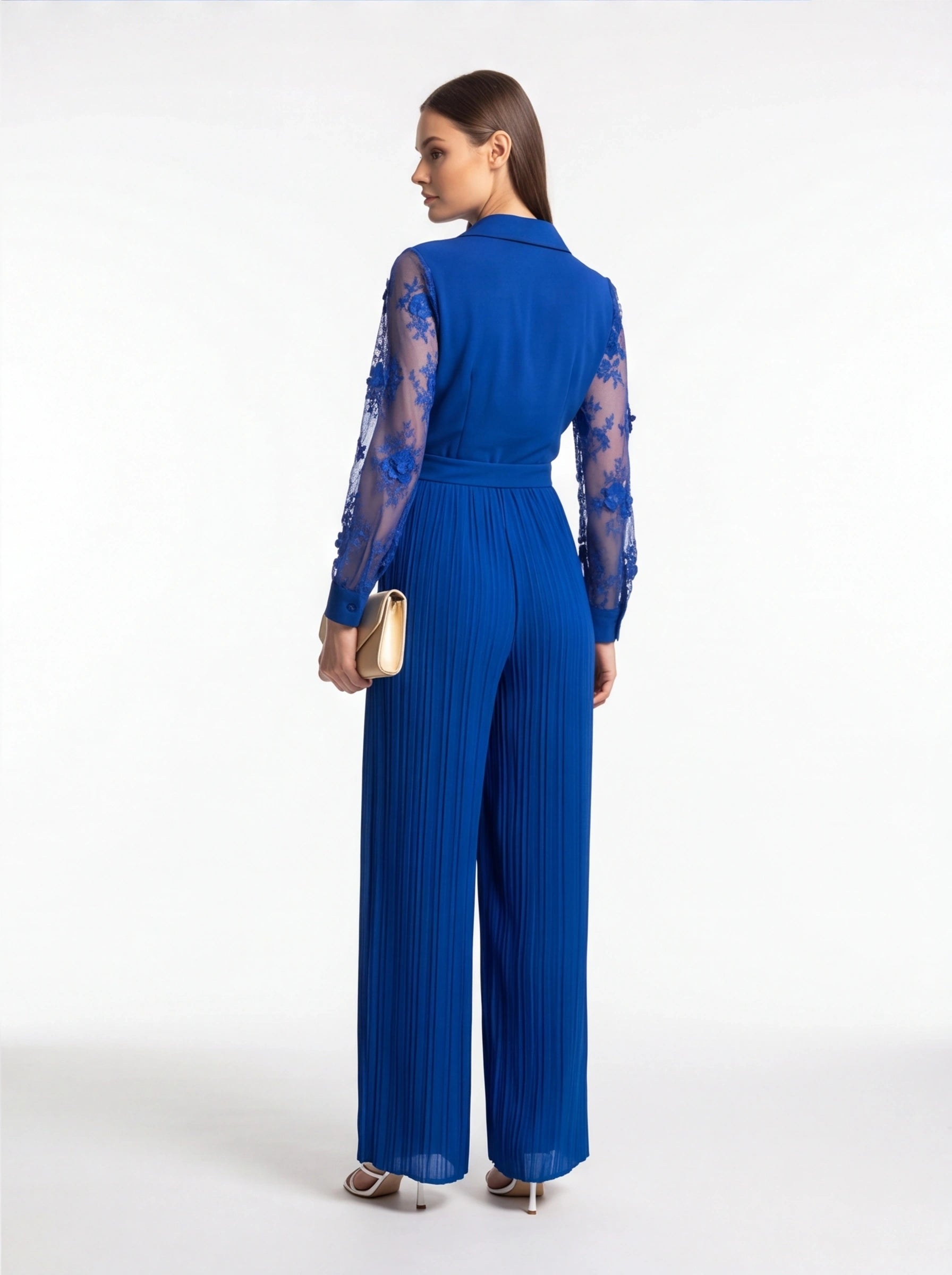Jamota blue jumpsuit with sheer floral lace sleeves, belt at waist, and pleated wide legs.